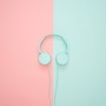 Minimalist headphones on a pink and mint background, artistic and modern.